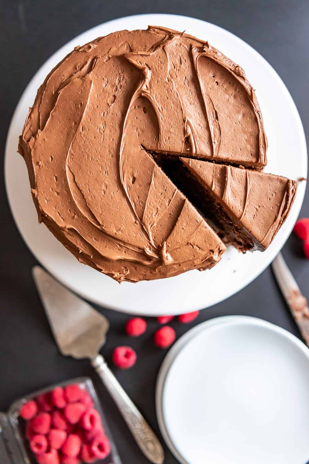 A chocolate cake with a slice cut and slightly moved out of place.