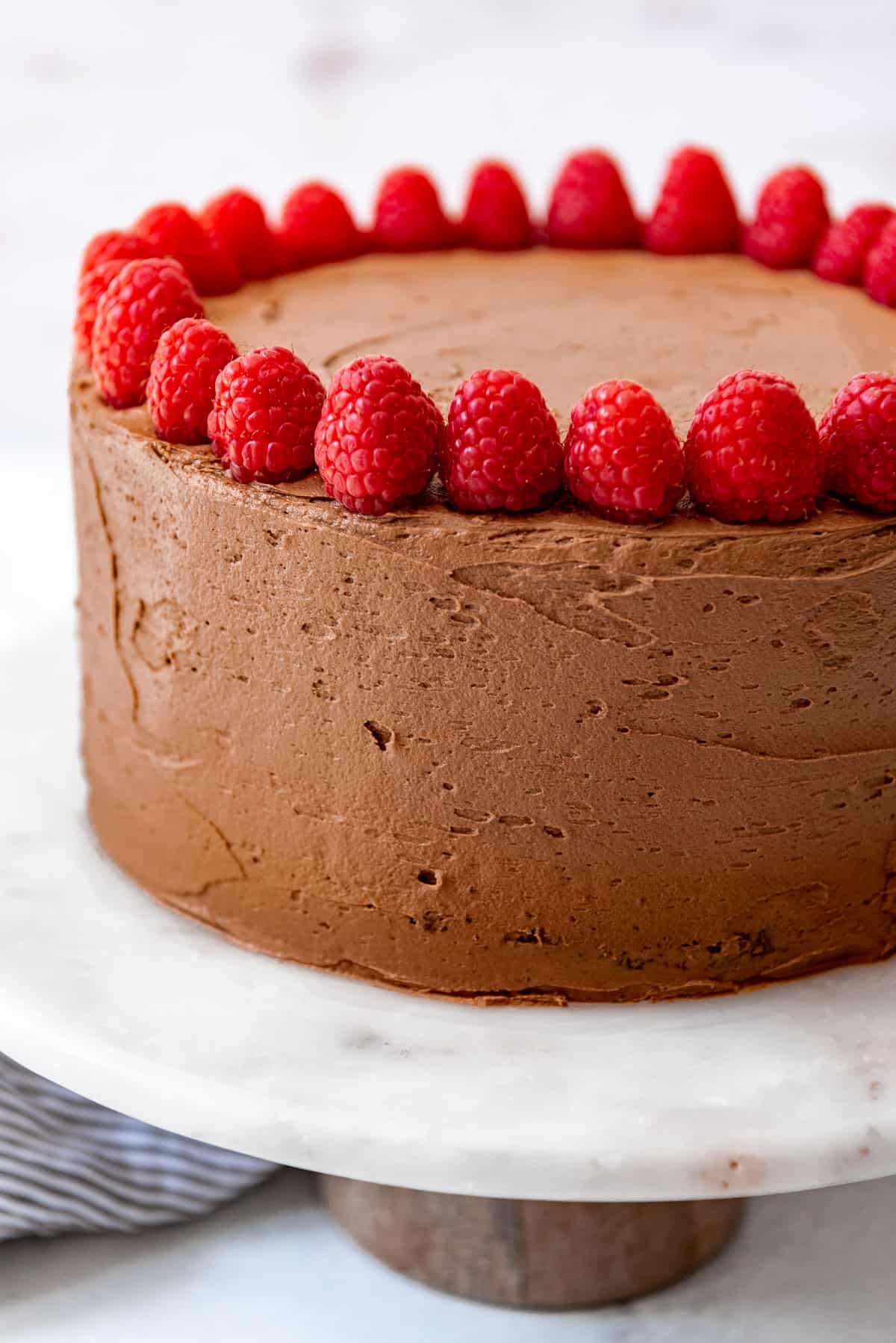 A homemade chocolate cake on a cake stand.