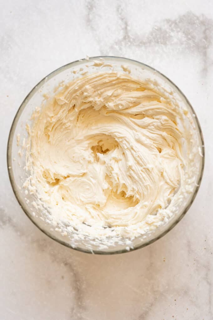 Creamy white vanilla buttercream frosting in a glass bowl.