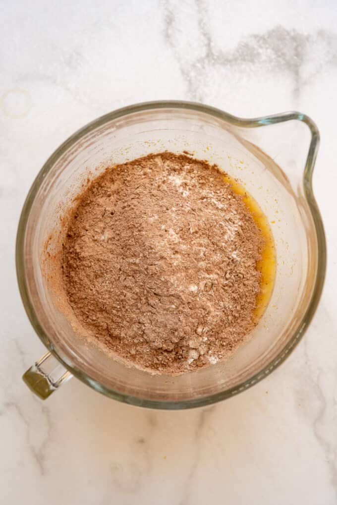 Adding dry ingredients of cocoa powder and flour to cake batter.