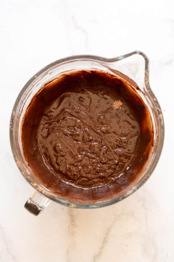 Chocolate cake batter in a glass bowl after mixing in dry ingredients.