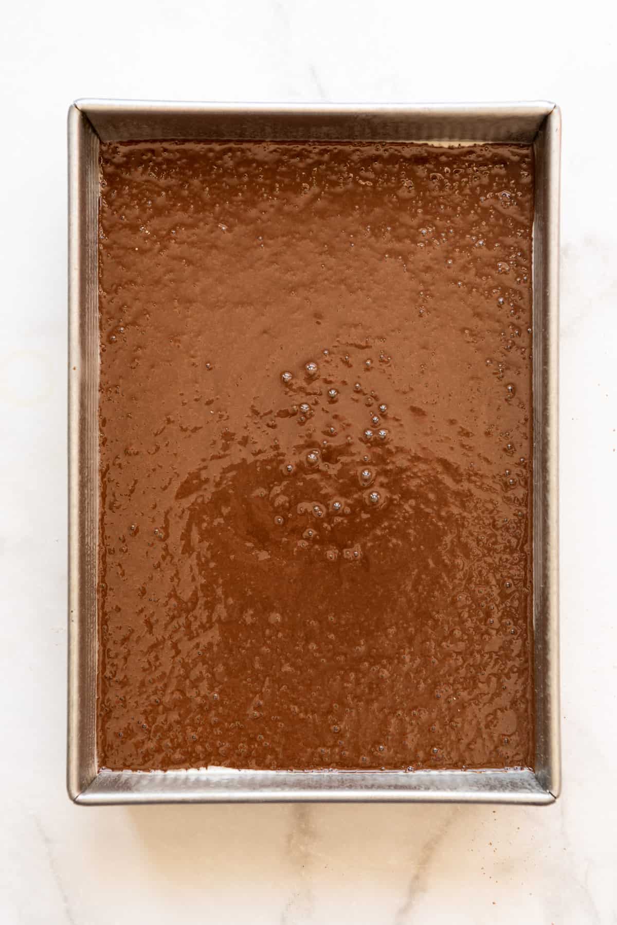 Chocolate cake batter in a rectangular pan.