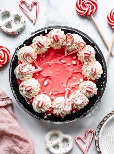 A no-bake candy cane peppermint cream pie with whipped cream swirls and candy cane pieces on top.