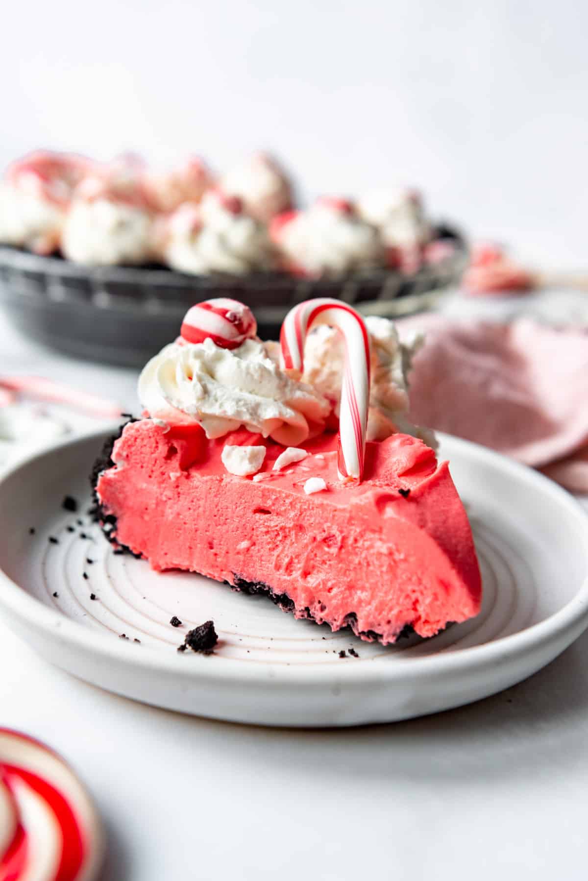 A slice of creamy no-bake peppermint cheesecake on a white plate.