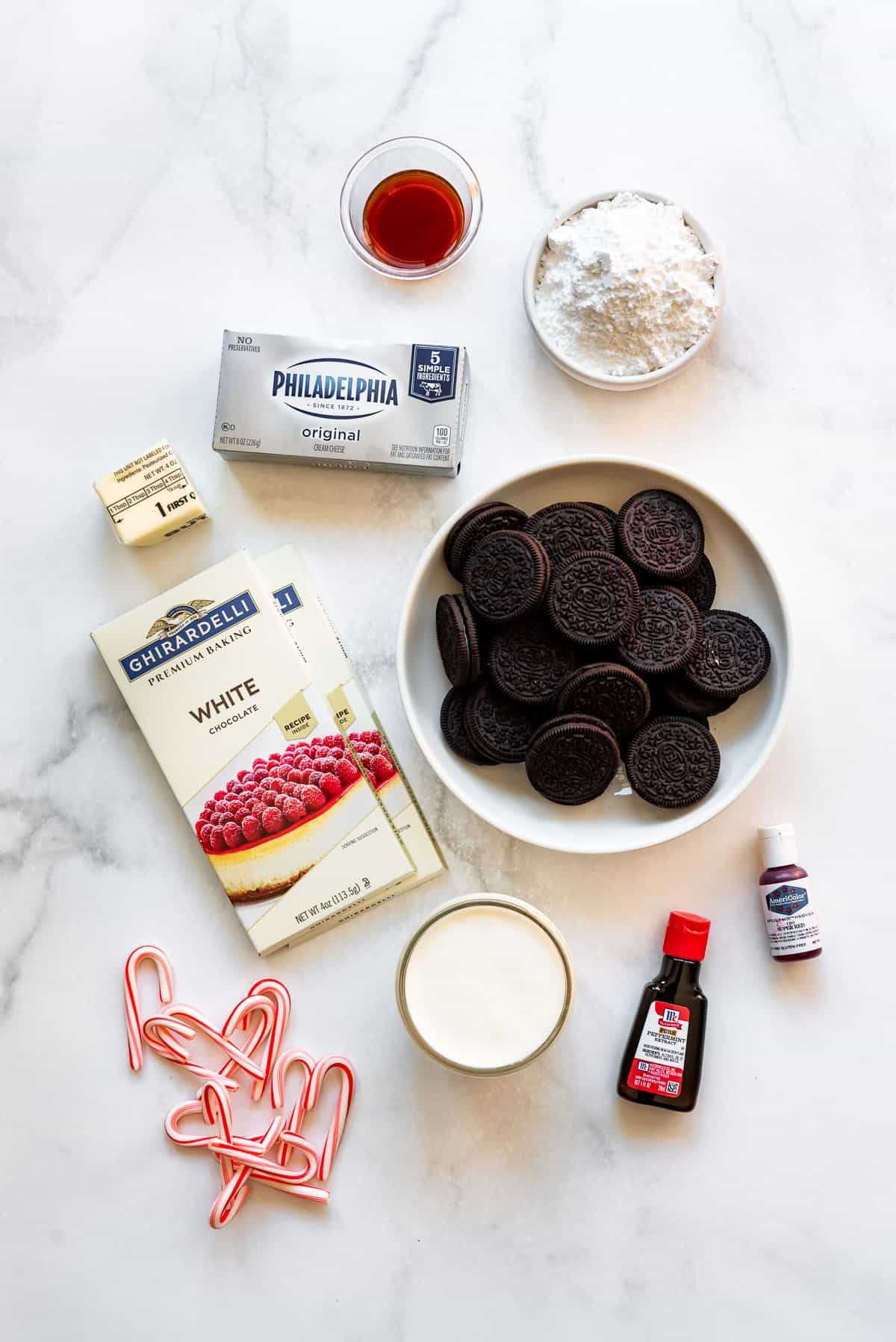 Ingredients for making a candy cane peppermint pie like Oreos, cream cheese, white chocolate, candy canes, and heavy cream.