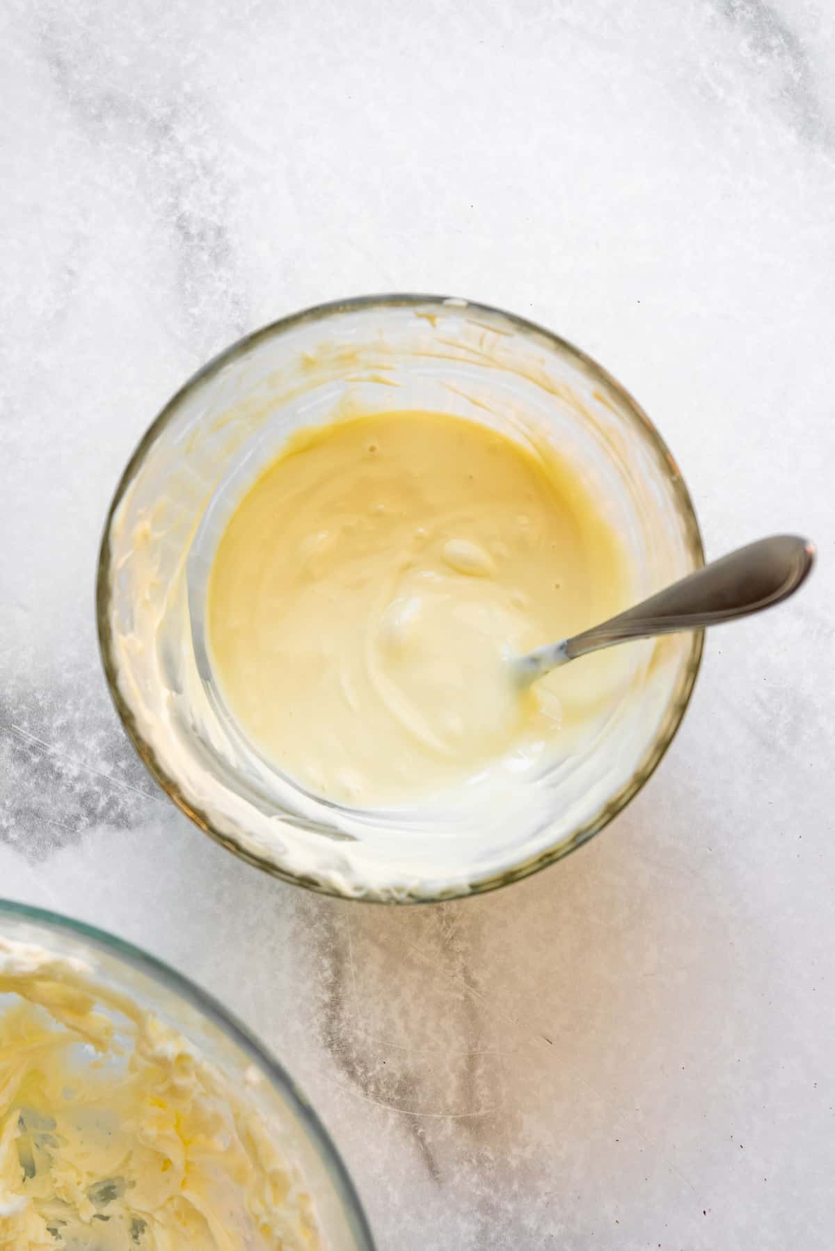 Melted white chocolate in a bowl with a spoon.