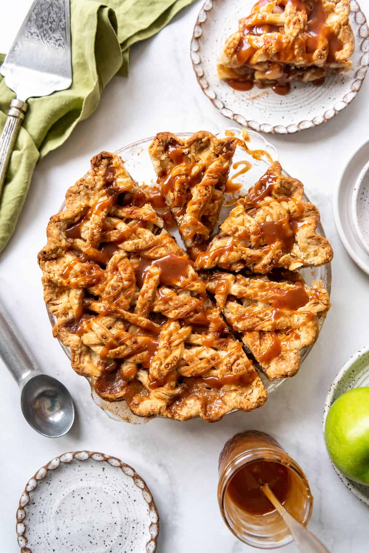 A salted caramel apple pie with some slices removed.