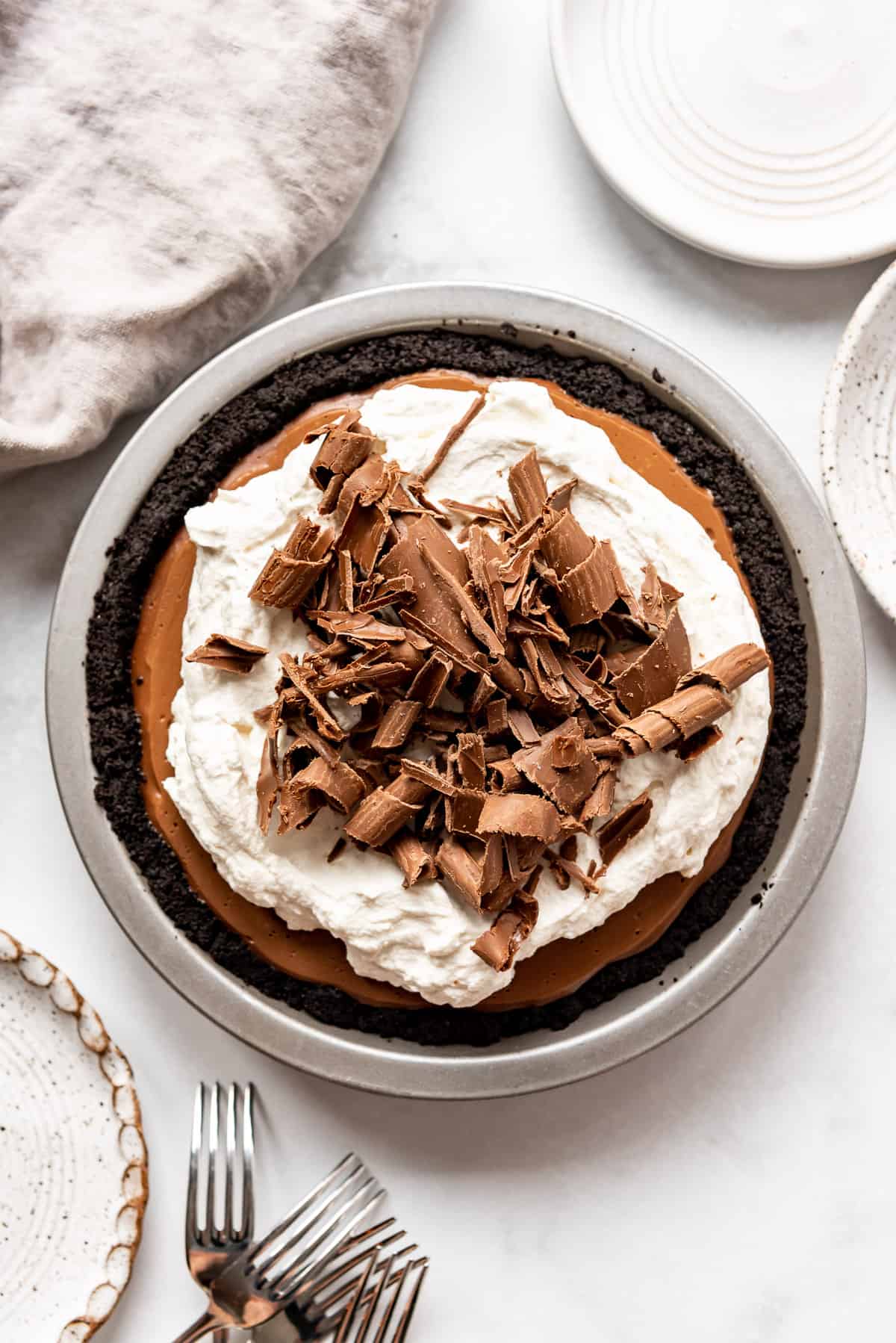 An image of an easy no-bake chocolate cream pie with an oreo pie crust, whipped cream, and chocolate shavings on top.