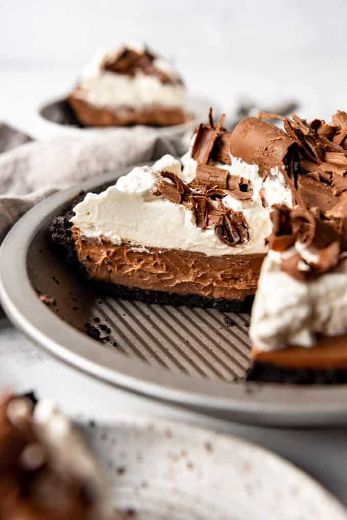 An image of an easy chocolate cream pie made from scratch and slices already cut out of it, showing the rich, creamy chocolate filling.