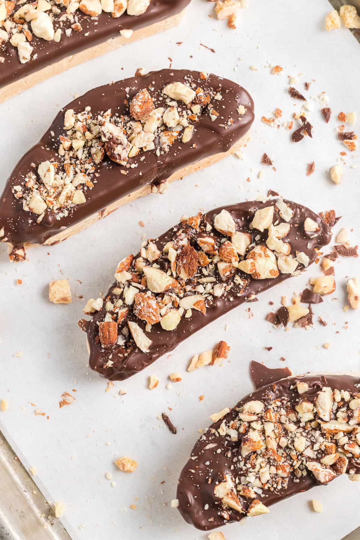 Sliced biscotti decorated with melted chocolate and toasted almonds.
