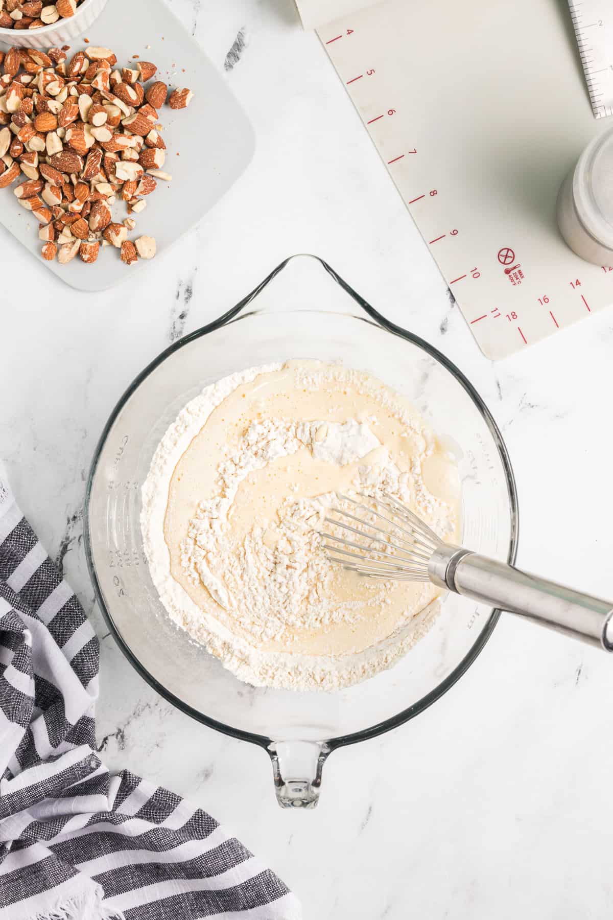 Stirring wet ingredients into dry ingredients to combine.