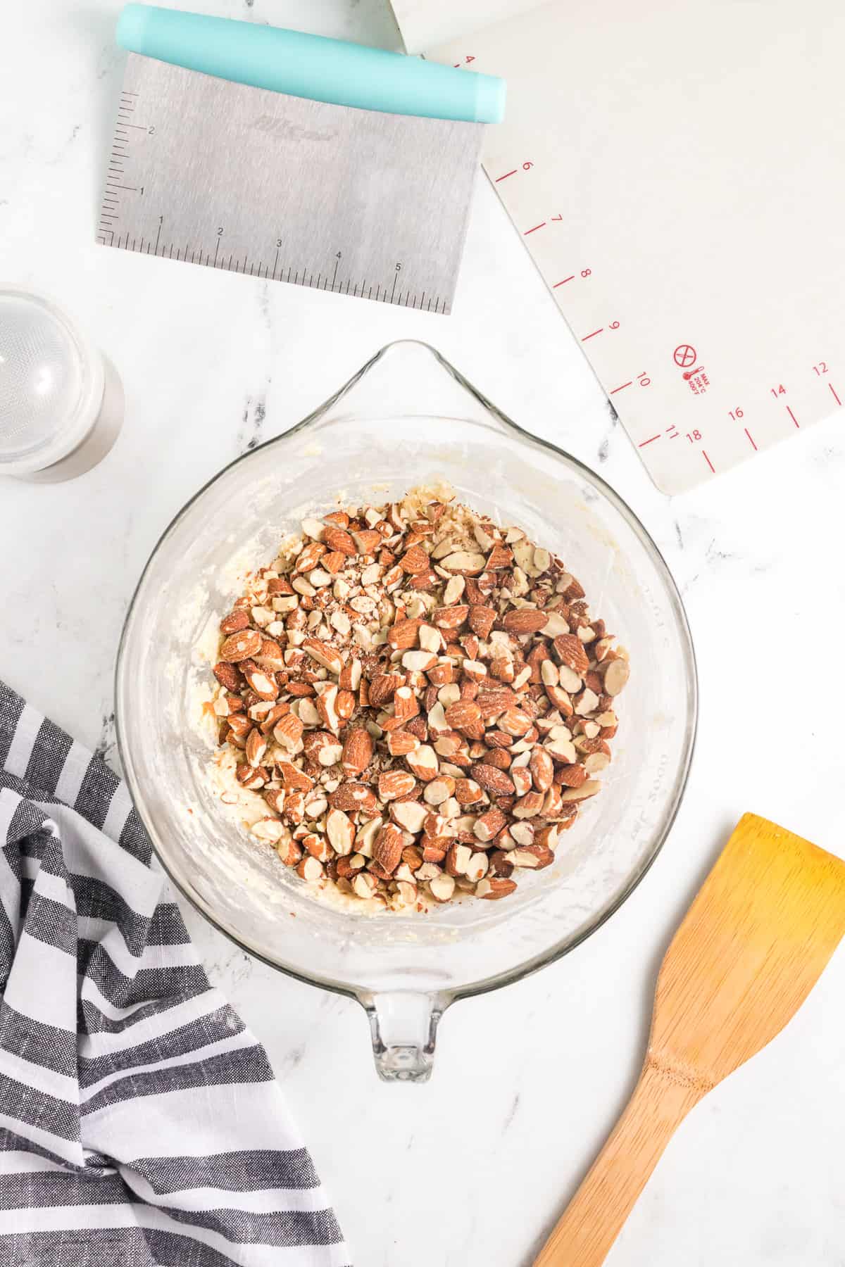 Adding chopped toasted almonds to biscotti dough.