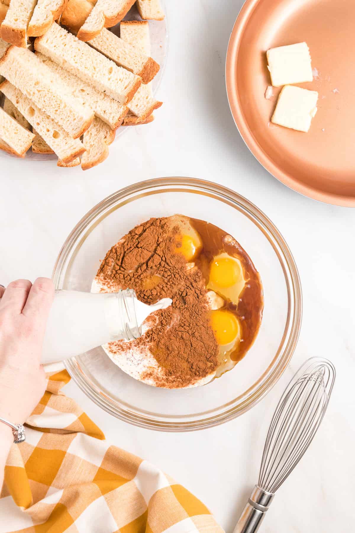 Adding milk to eggs, vanilla, and cinnamon for French toast sticks.