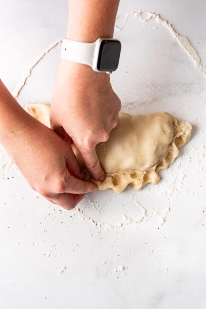 Making crimps along the edges of a Cornish pasty.