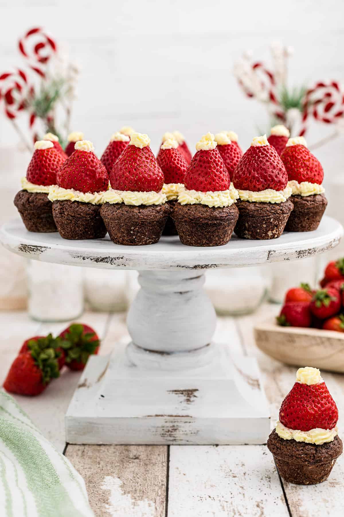A white cake stand with Santa Hat Brownie Bites arranged on top.