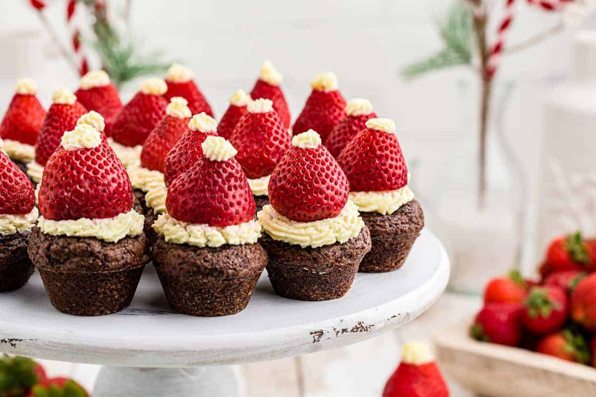 Brownie bites topped with strawberries and cream to look like Santa hats.