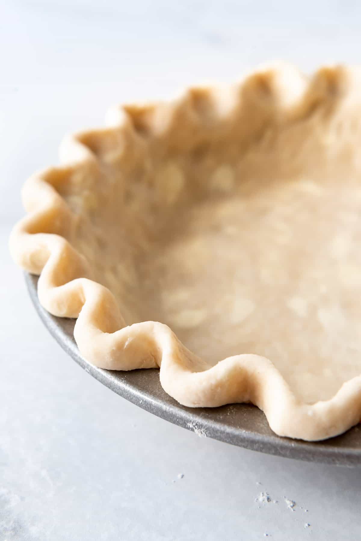 A crimped edge of an unbaked pie crust.
