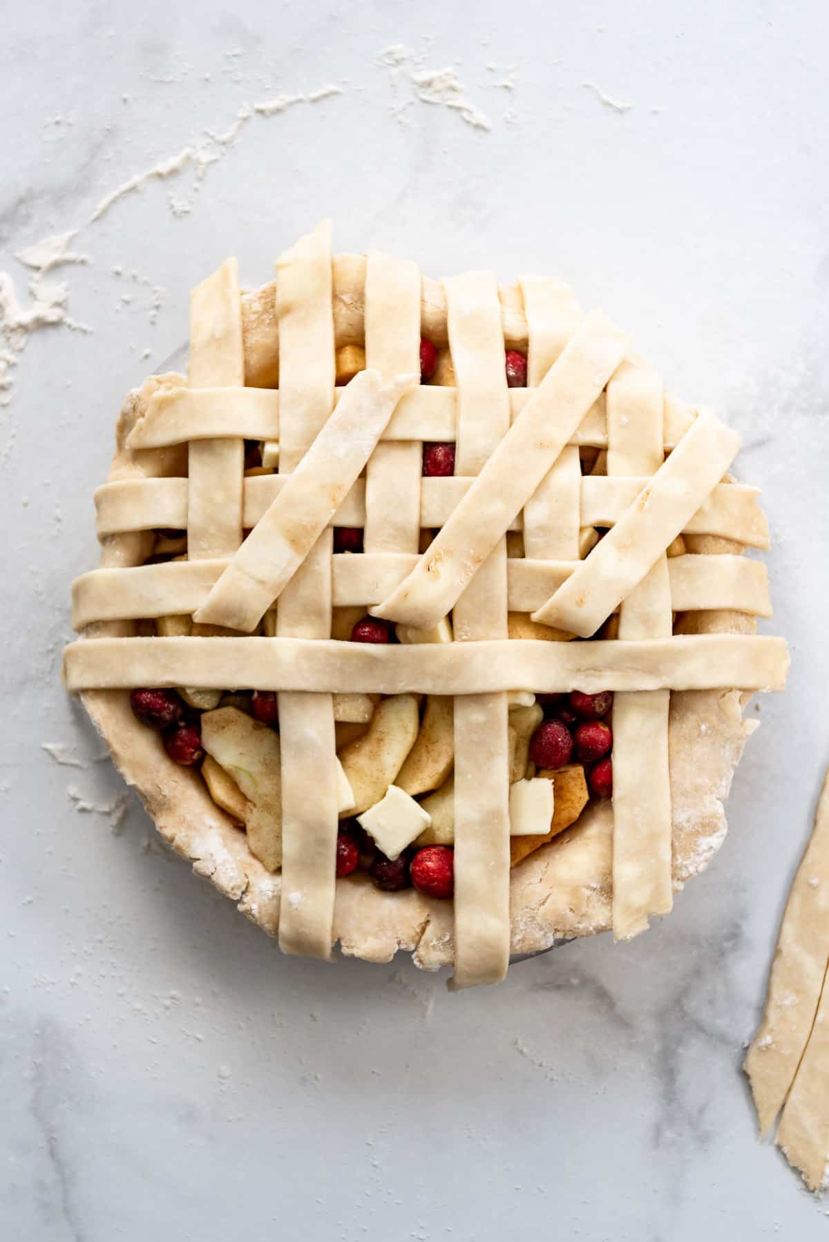 Adding more lattice pie crust strips.