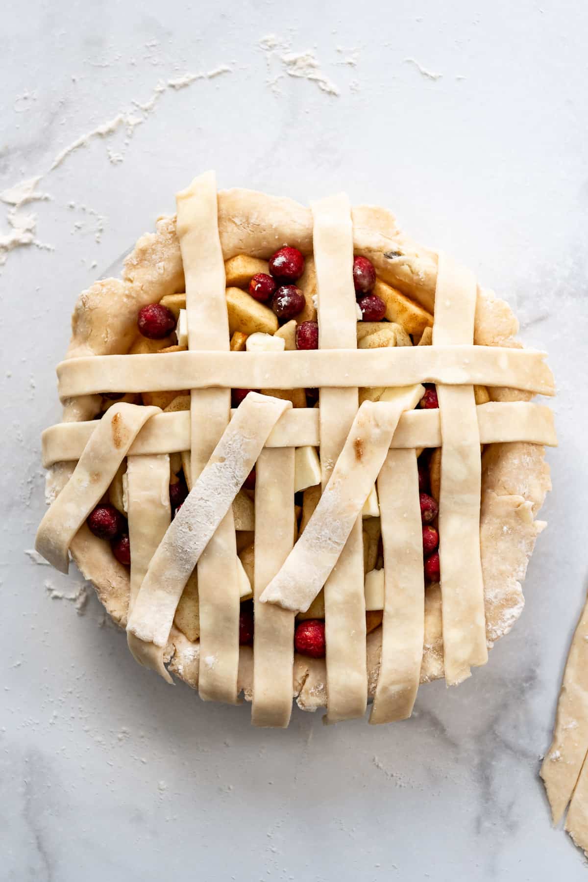 Continuing to weave the lattice pie crust.