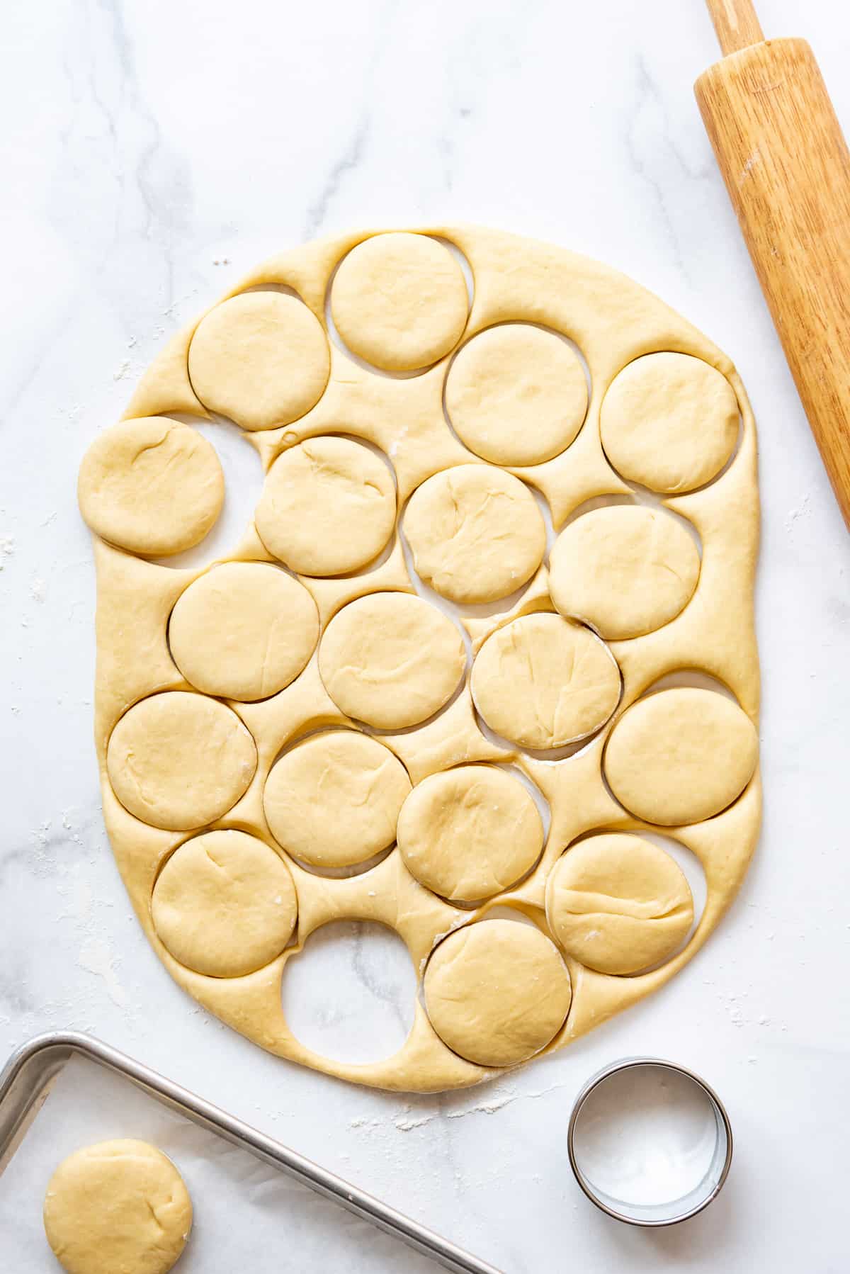 Cutting out soft yeast dough to make homemade packzi donuts.