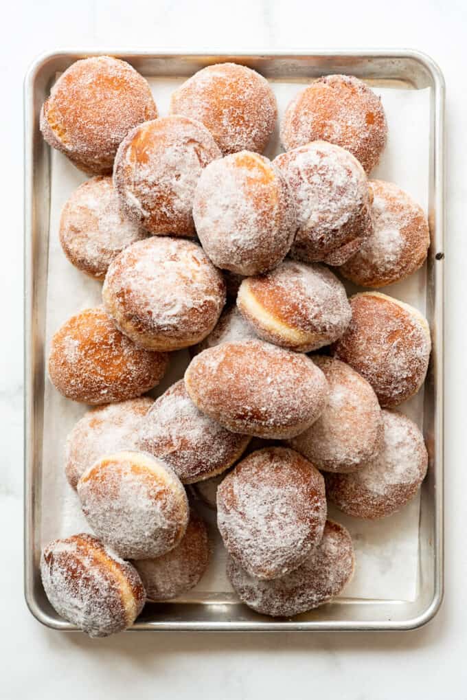 Fried donuts covered in granulated sugar.