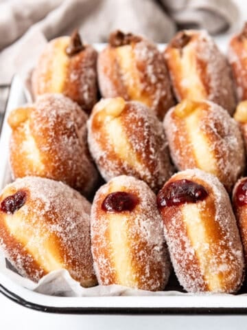 Three types of packzi jelly donuts arranged on end in rows.