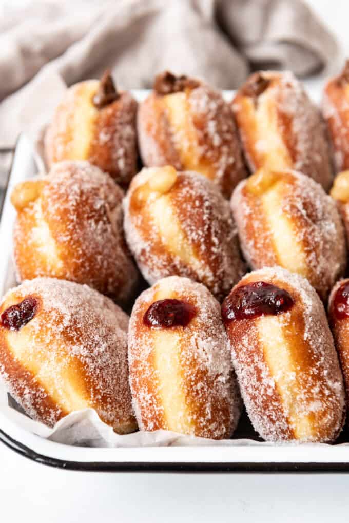 Three types of packzi jelly donuts arranged on end in rows.