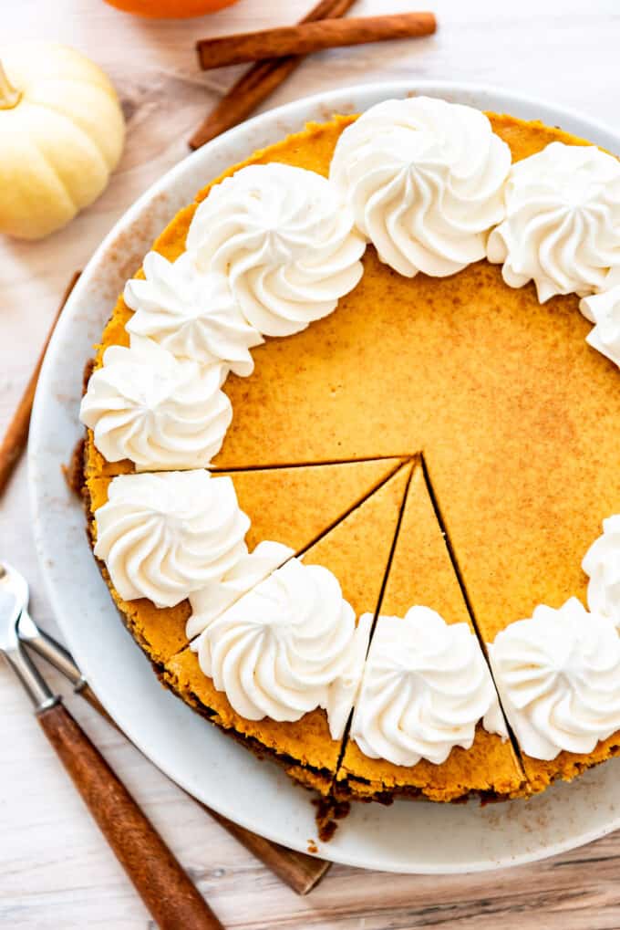 A homemade pumpkin cheesecake with three slices cut into it.