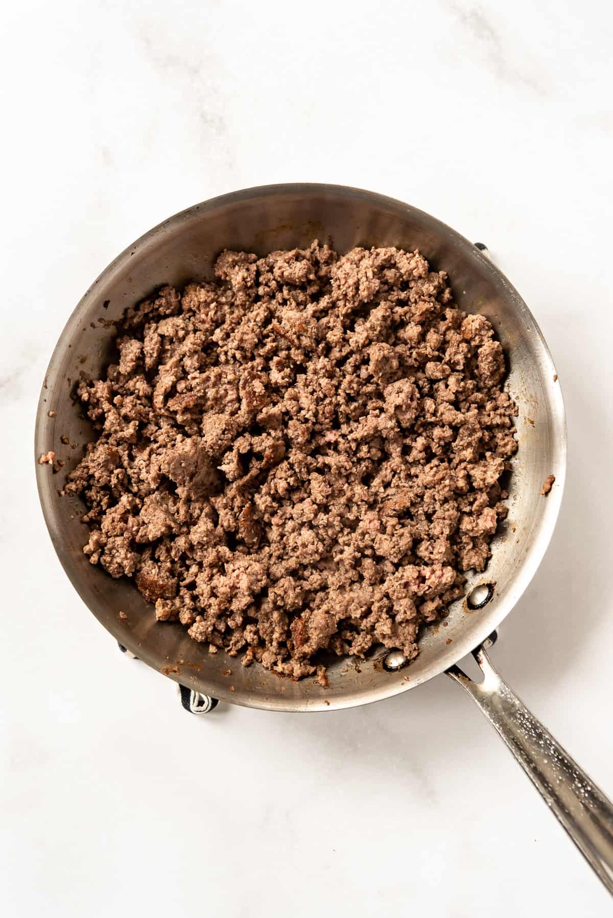 Browned ground beef in a skillet.