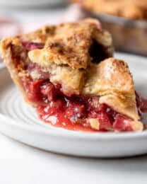 A slice of strawberry rhubarb pie on a plate.