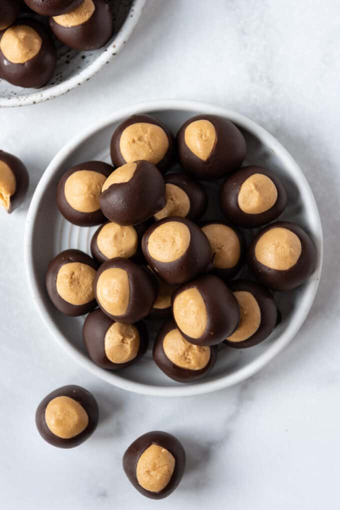 An overhead image of chocolate covered peanut butter buckeyes on a white plate.