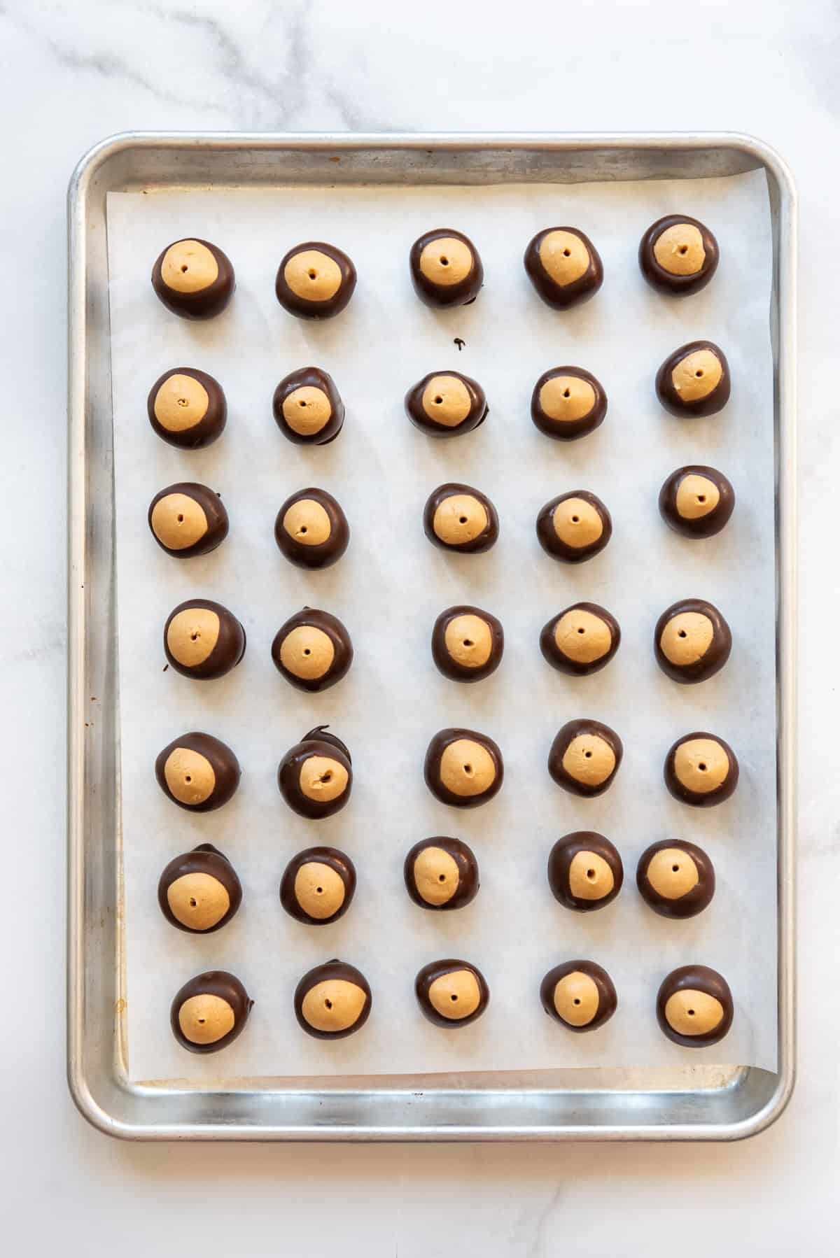Holes in the top of each buckeye from piercing them with a toothpick to dip them in chocolate.