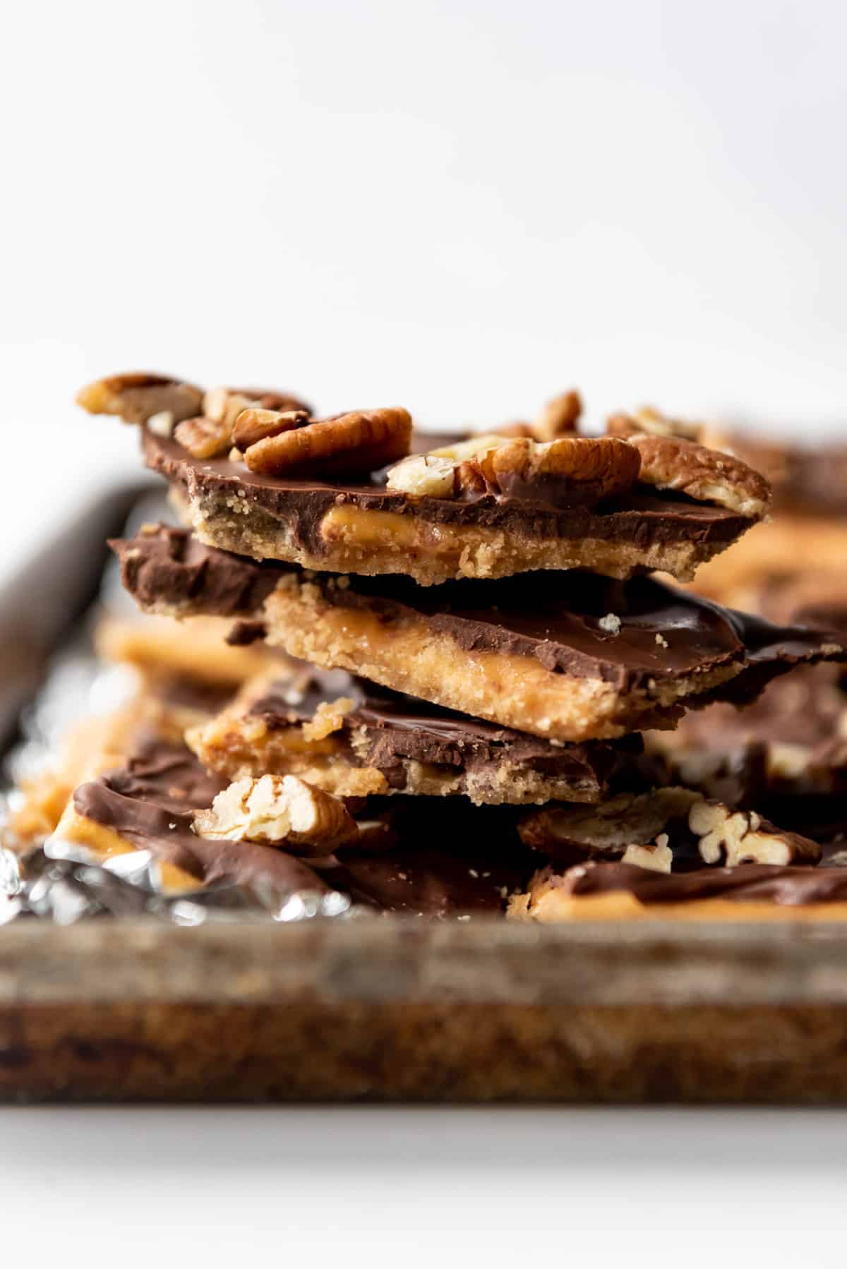 A stack of Christmas crack saltine cracker toffee on a baking sheet.