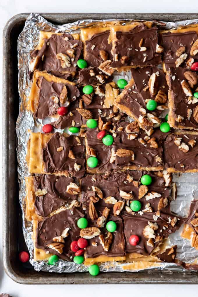Broken up chunks of easy cracker toffee on a baking sheet lined with foil.