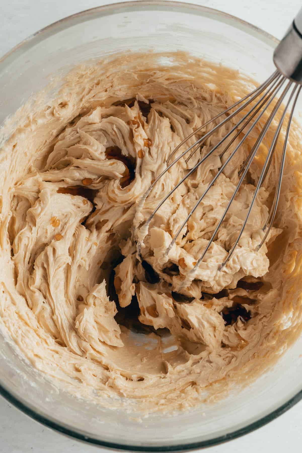 Combining softened butter and sugars in a mixing bowl.