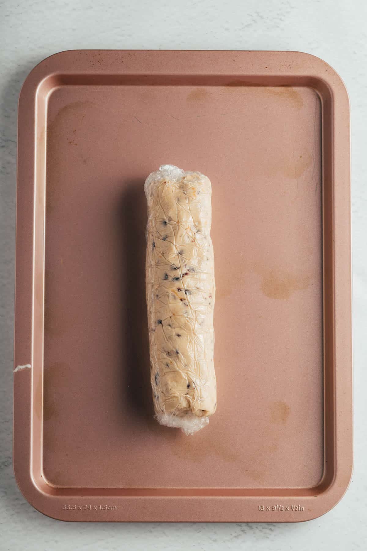 A chilled and wrapped log of shortbread cookie dough.