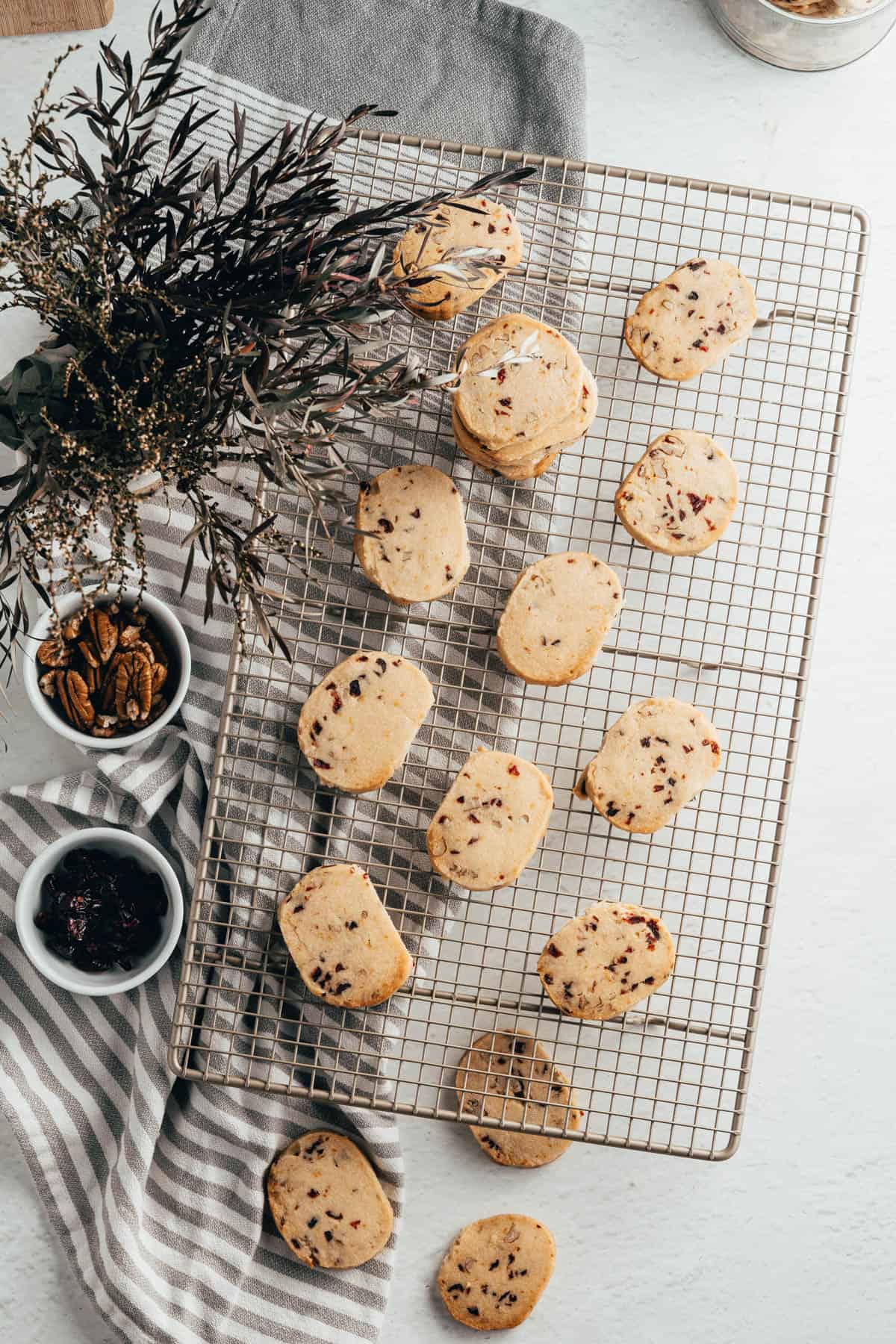 An overhead image of cranberry pecan shortbread cookies on a wire rack.
