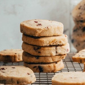 An image of a stack of cranberry pecan shortbread cookies.