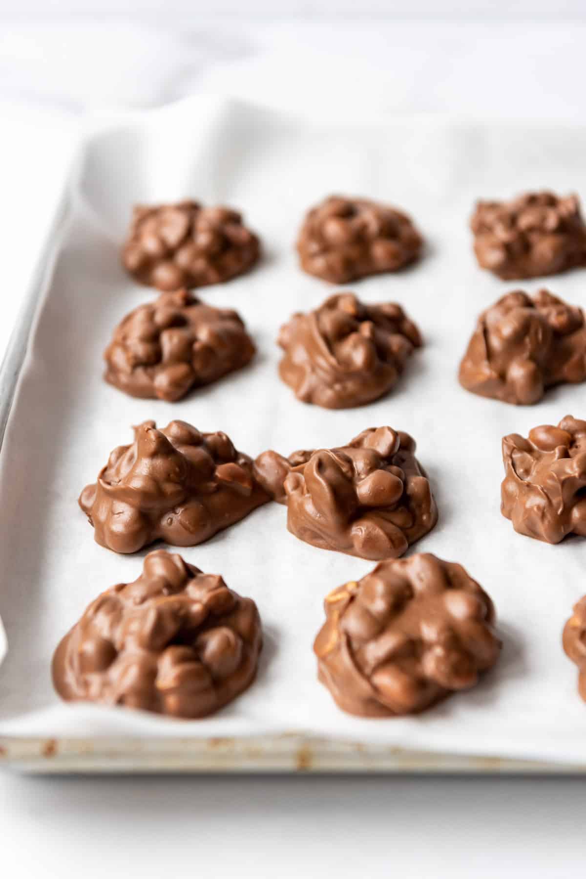 Peanut clusters cooling on a baking sheet.