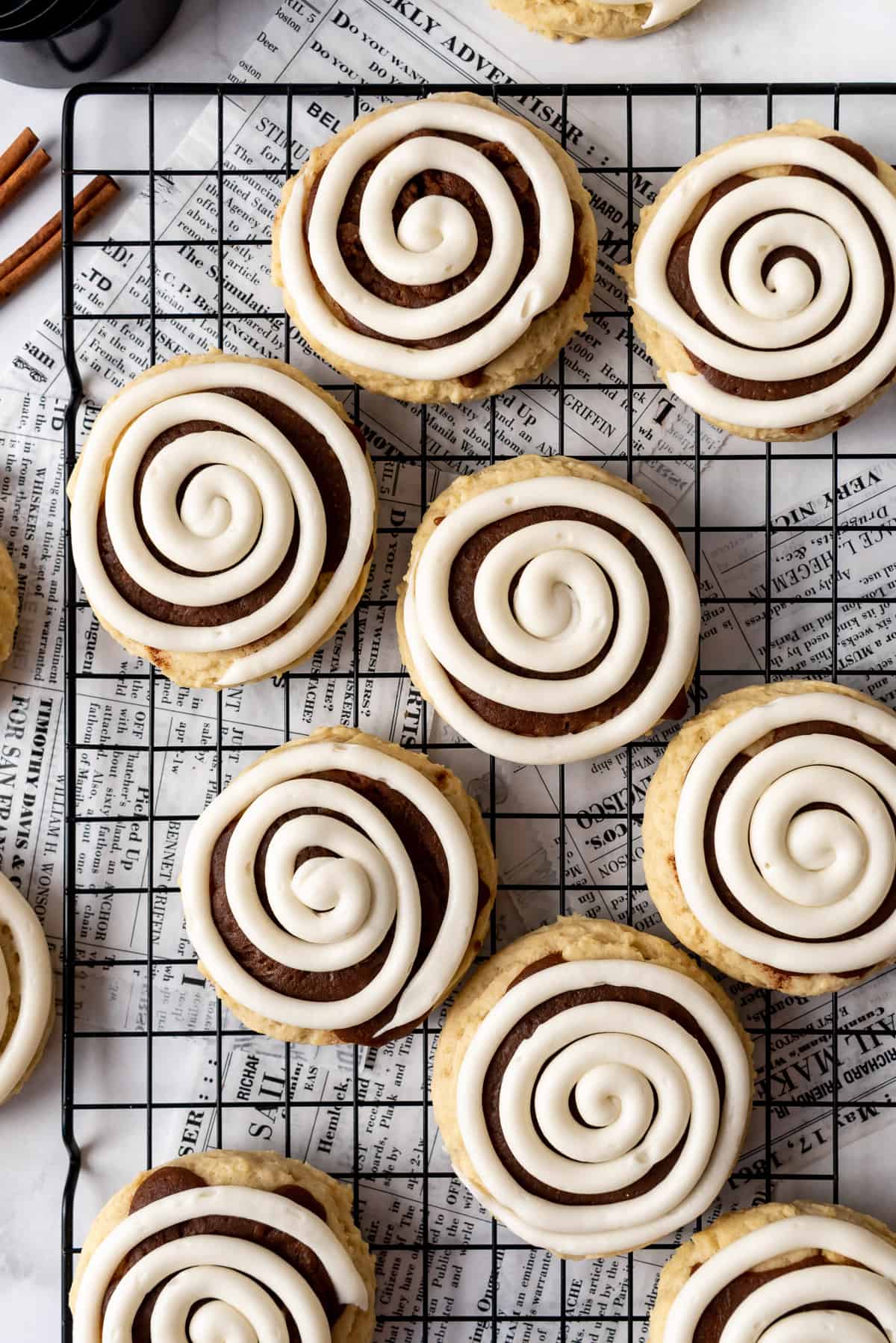An overhead image of swirls of cream cheese frosting on cinnamon roll cookies.