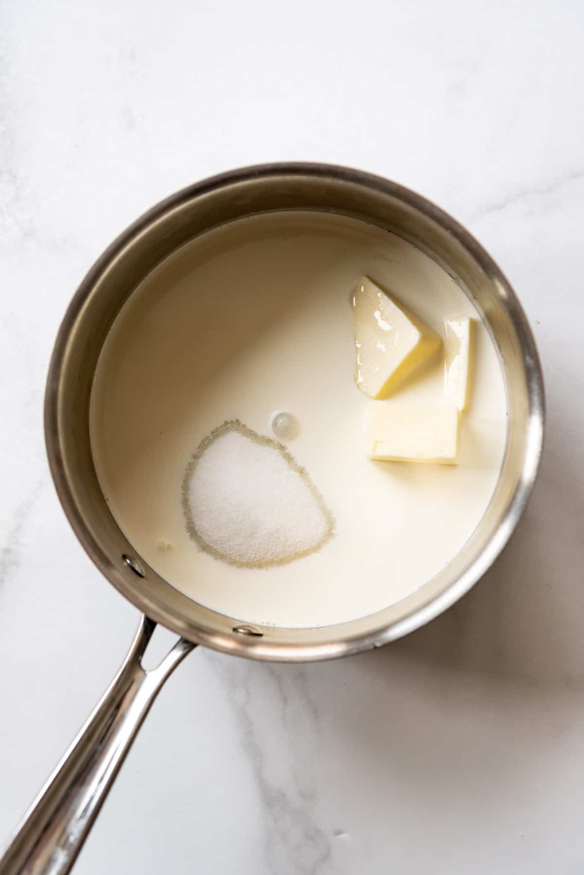 Combining sugar, butter, and heavy cream in a medium saucepan.