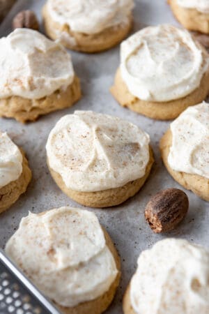 Frosted eggnog cookies on a baking sheet lined with parchment paper.