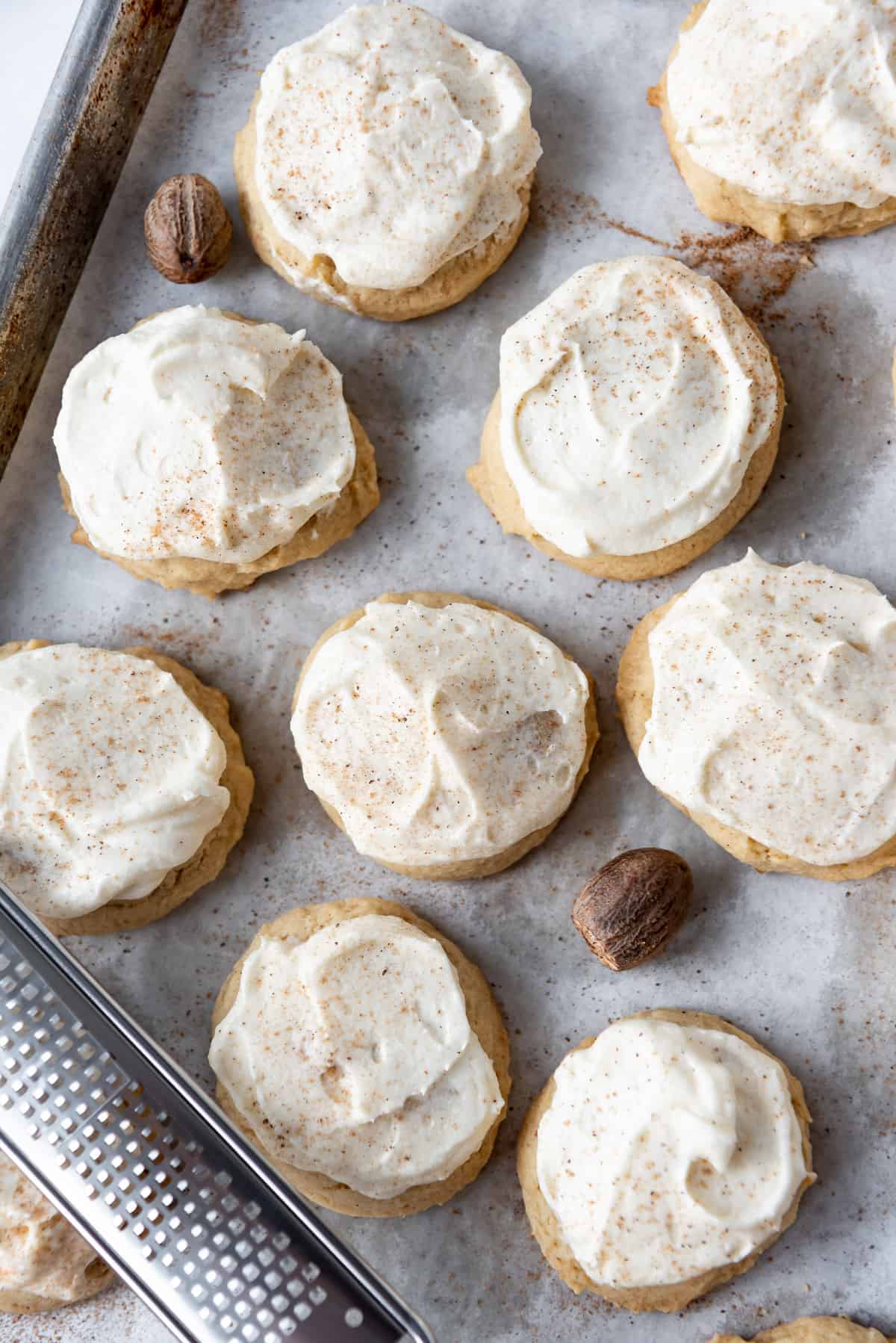 An overhead image of frosted eggnog cookies dusted with freshly grated nutmeg.
