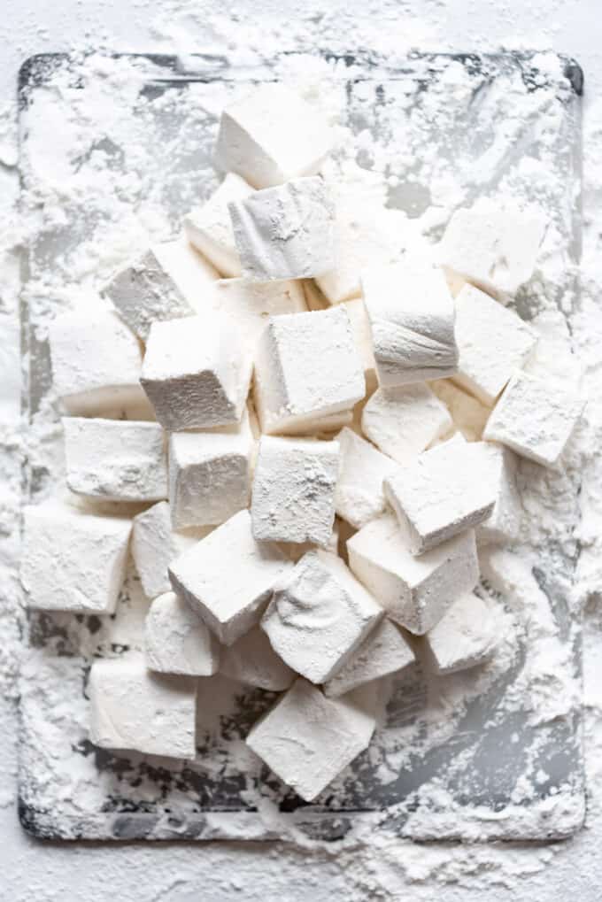 Tossing homemade marshmallows in powdered sugar and cornstarch right after cutting so they don't stick.