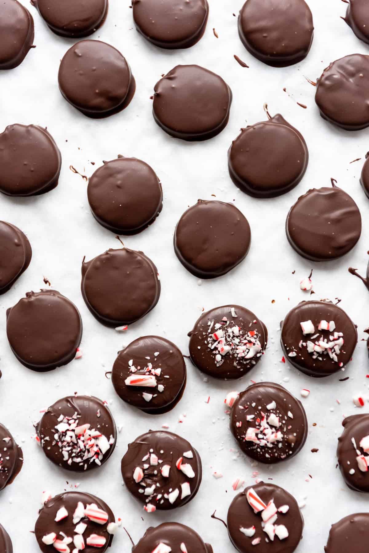 Homemade peppermint patties setting up on a baking sheet so the chocolate can harden.