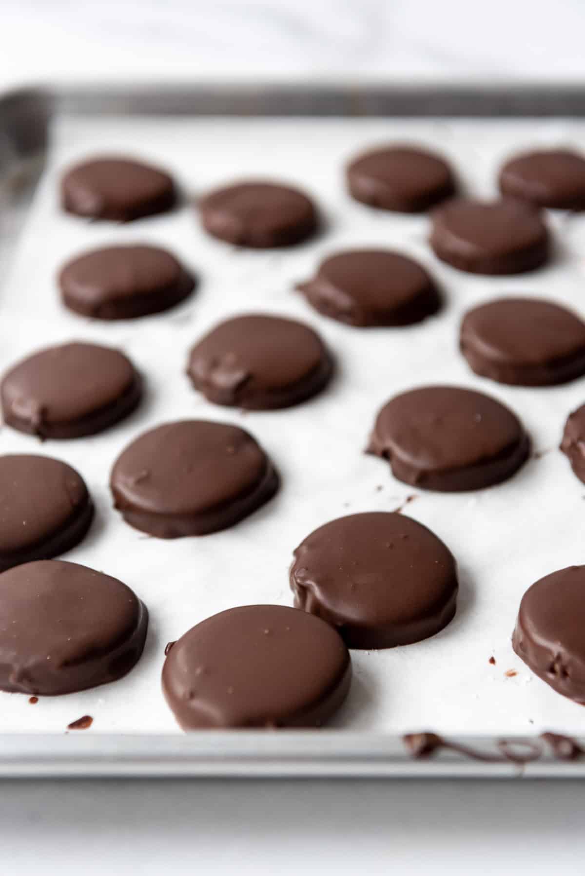 Chocolate coated soft peppermint cream filling on a baking sheet lined with parchment paper.