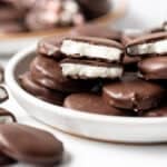 Homemade peppermint patties candies stacked on a plate.