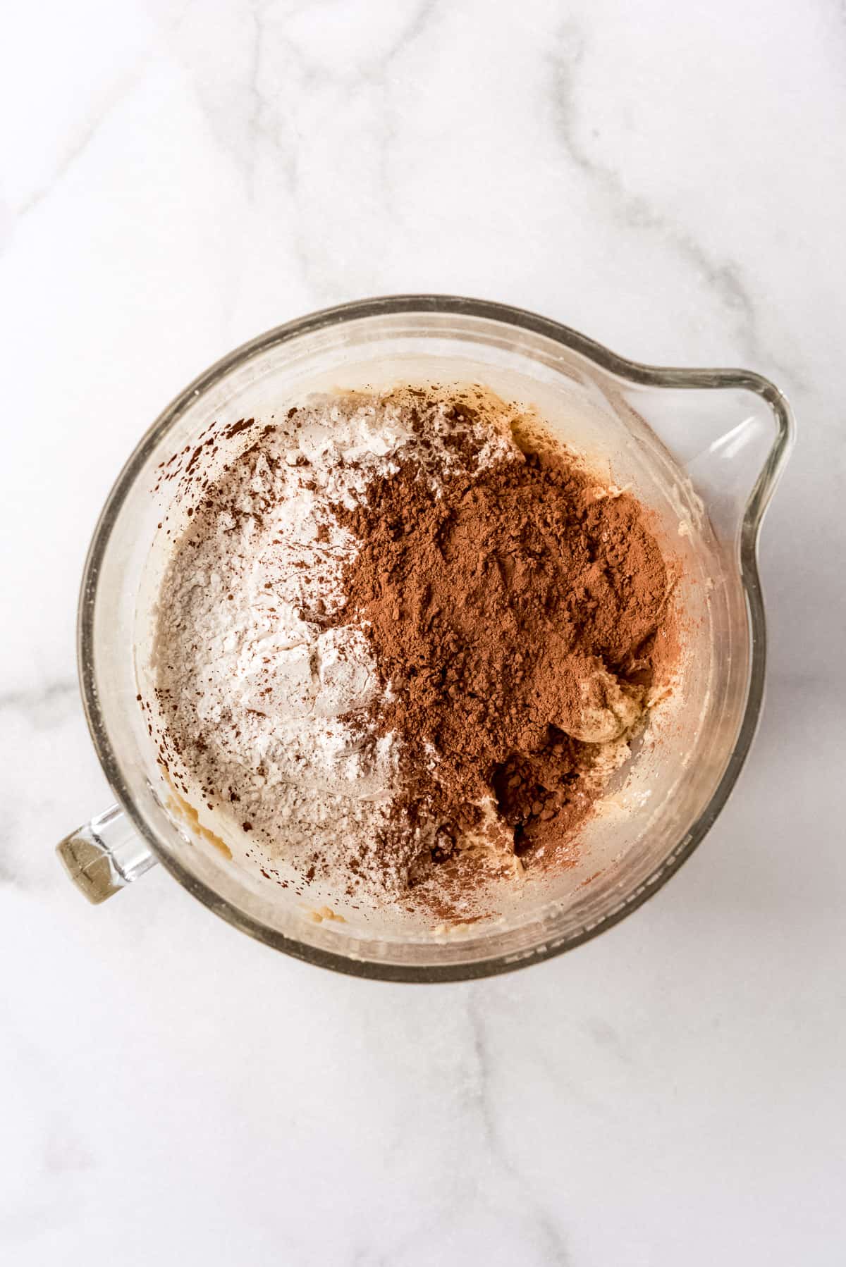 Adding flour and cocoa powder to make chocolate cookie dough.