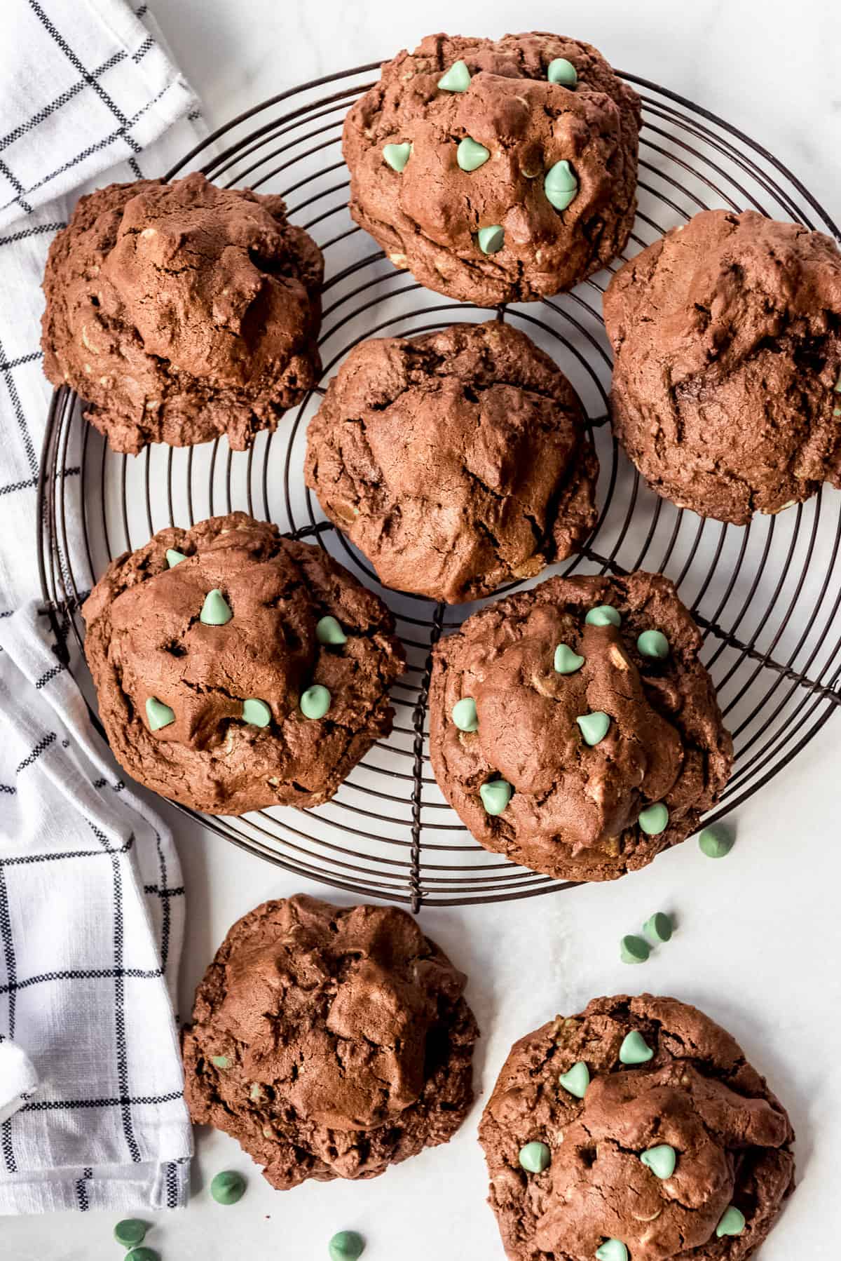 Oversized mint-chocolate cookies on a wire baking rack.