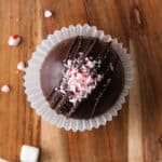 A hot cocoa bomb decorated with crushed peppermint candy canes on top.
